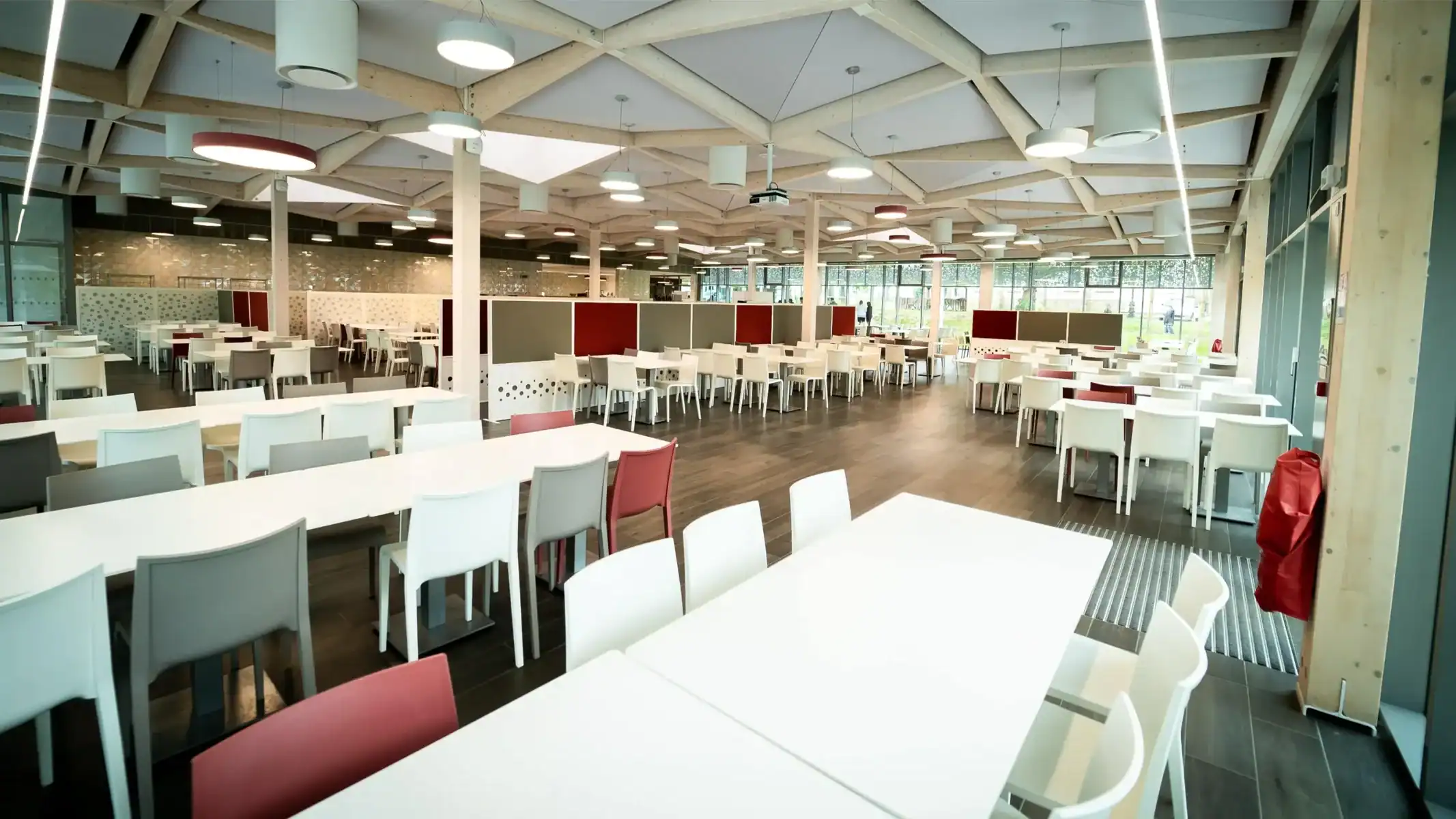 Modern school cafeteria with ample seating, natural light, and contemporary design for student dining.