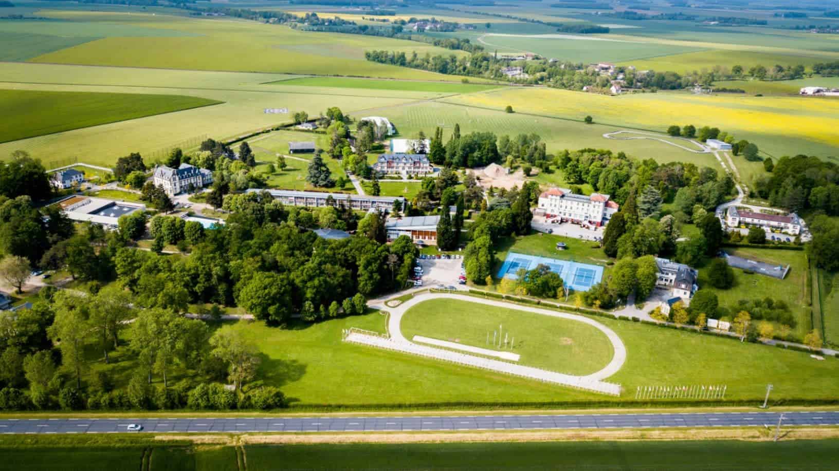 Sprawling international school campus with sports facilities and scenic countryside views.