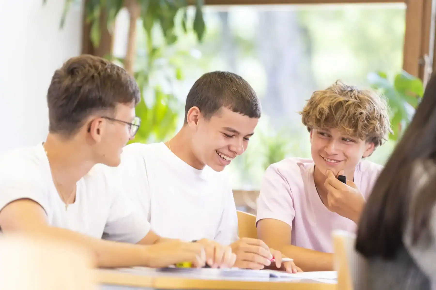 Young diverse students studying together, collaborative learning, cheerful classroom environment.