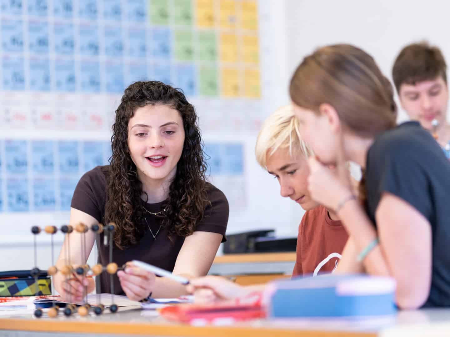 Engaged students collaborating in a classroom at a world school, focusing on science and international education.