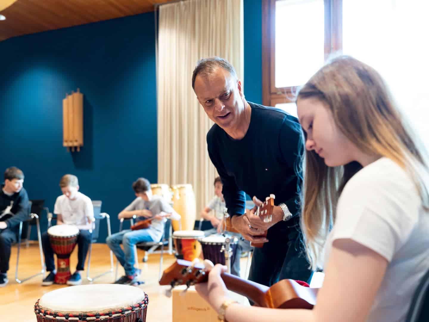 Music class at World Schools: students learning guitar and drums, fostering creativity and cultural exchange.