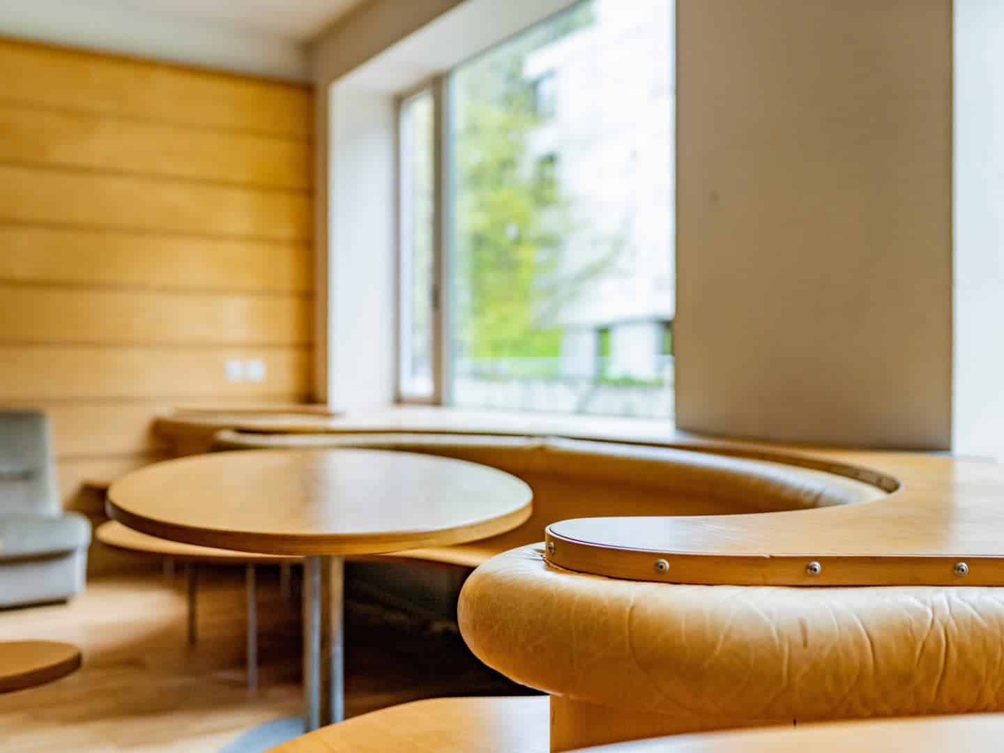 Modern classroom with wooden furniture and large windows at a world schools campus.