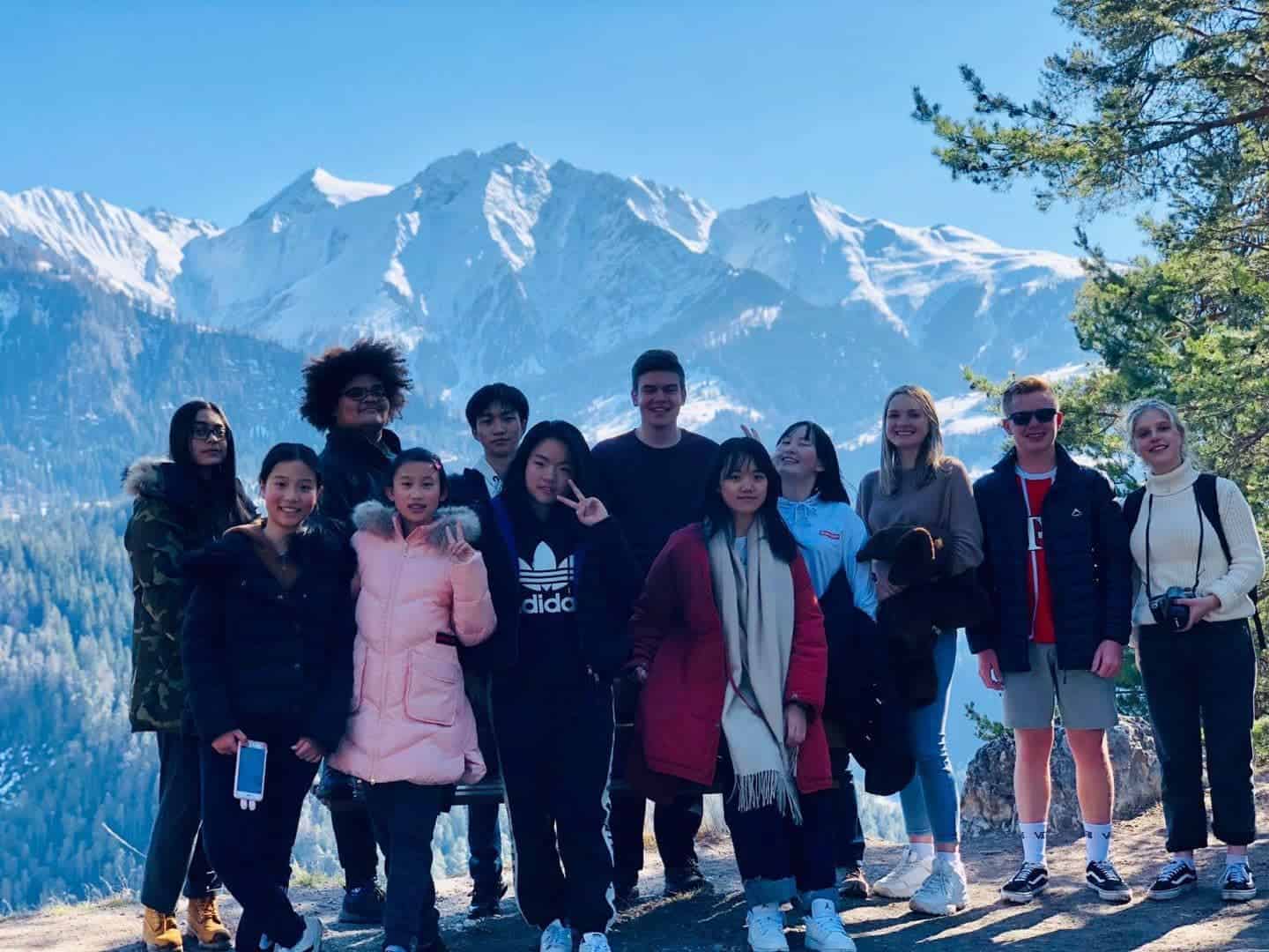 Students exploring snowy mountain landscape during school trip at world schools campus.