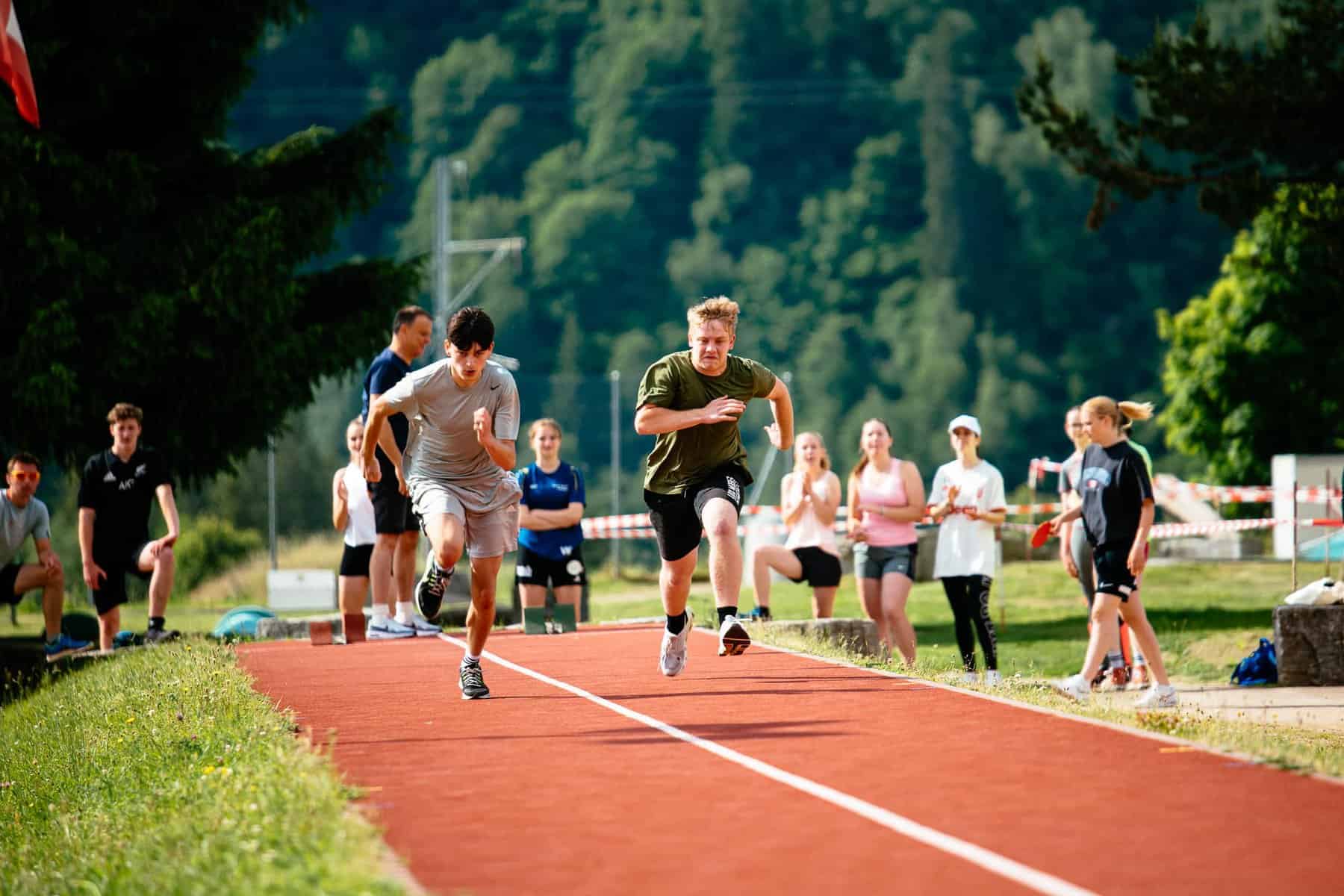 Young students running a race on an outdoor track at a school sports event.