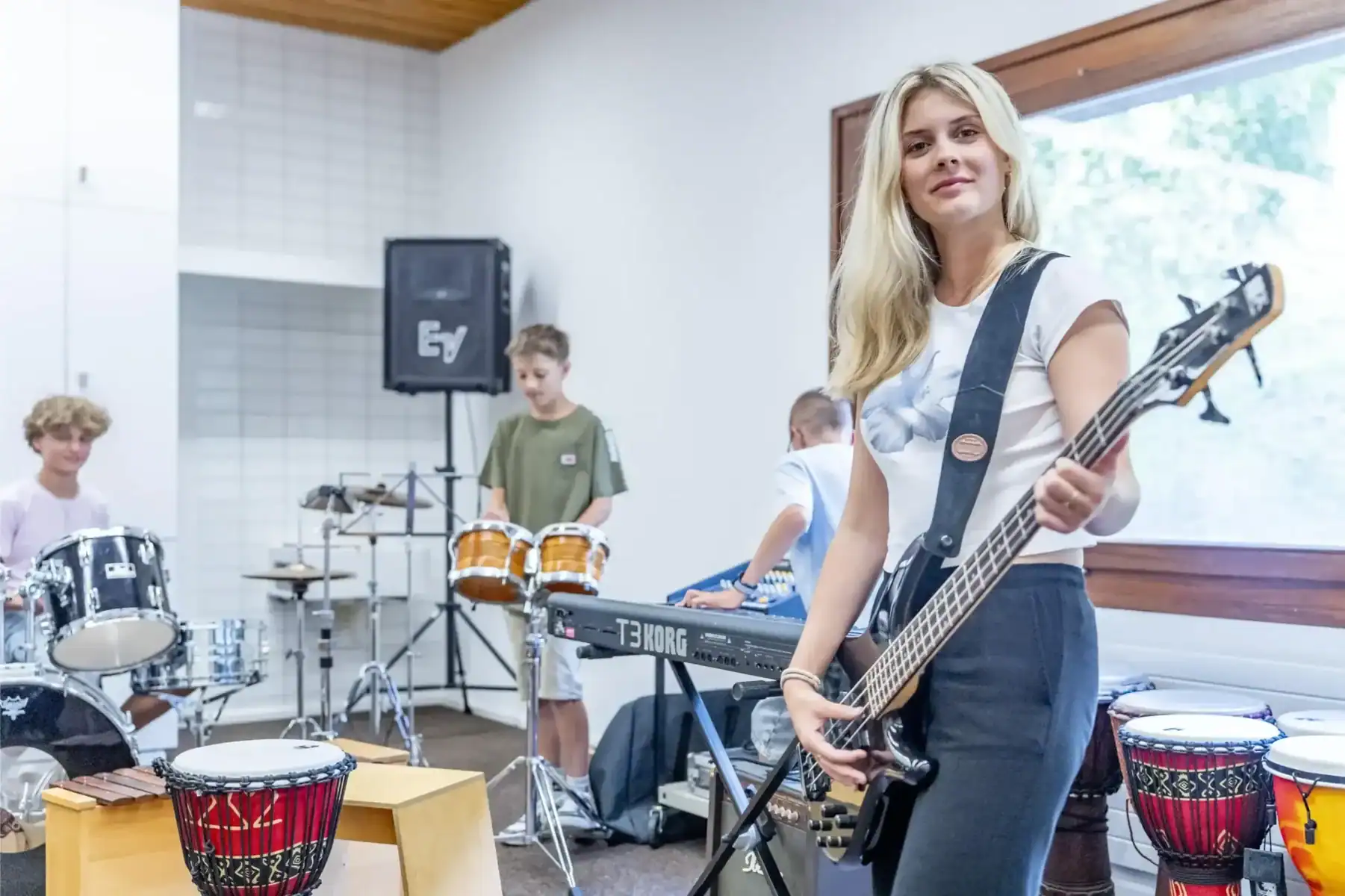 Young girl playing electric guitar during music class at a World Schools program event.