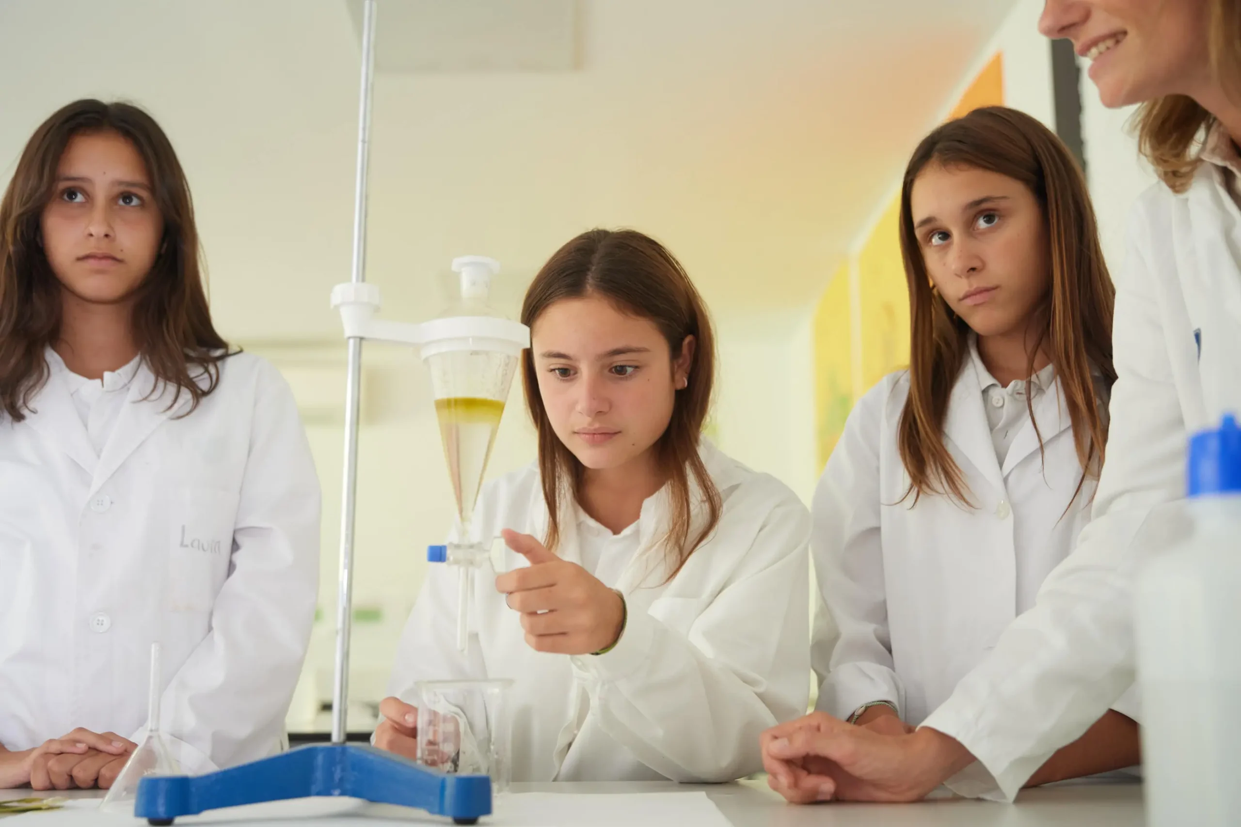 Student girls conducting science experiment in classroom, learning chemistry at world schools.