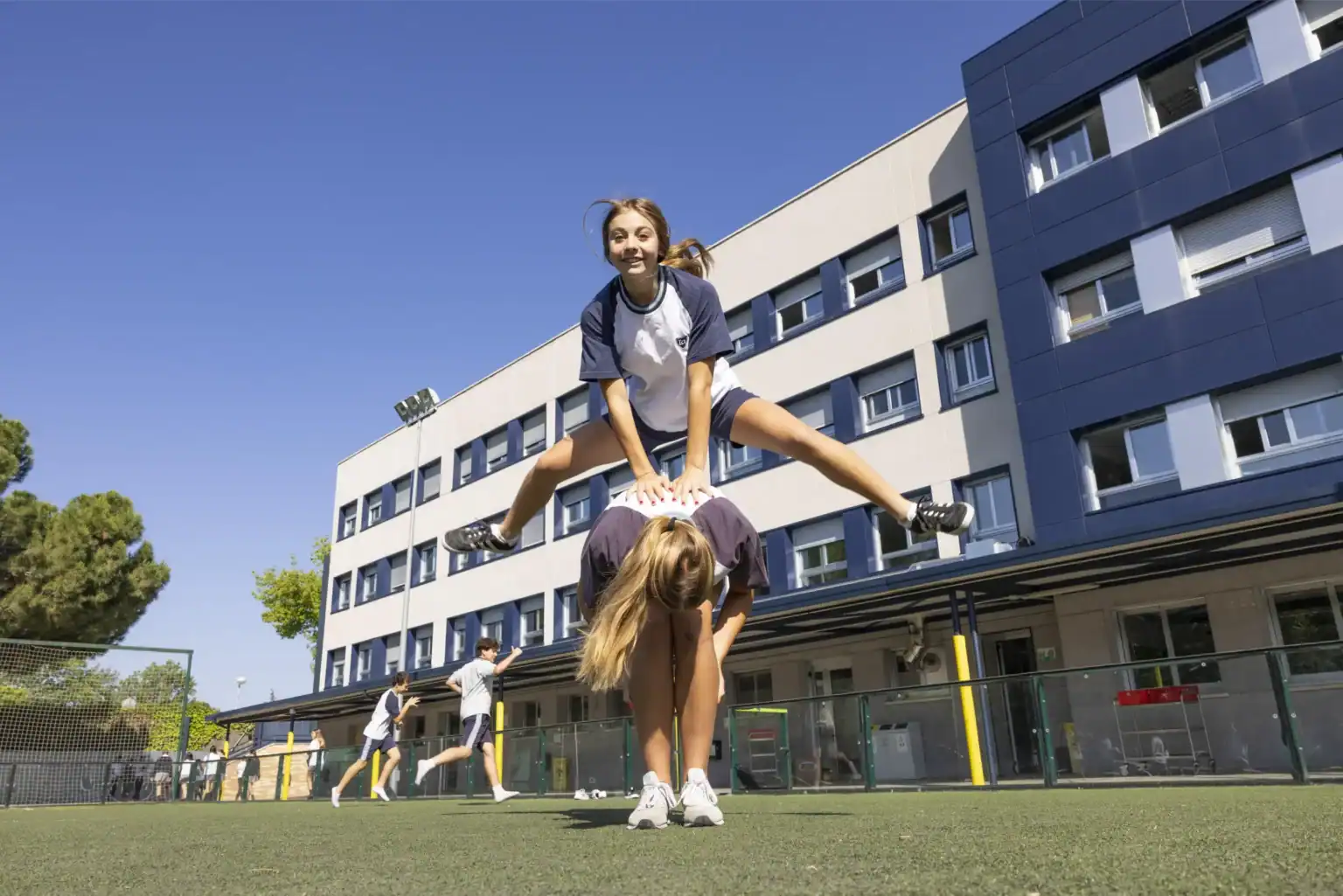 Young students playing on school sports field at World Schools campus, promoting active learning and teamwork.