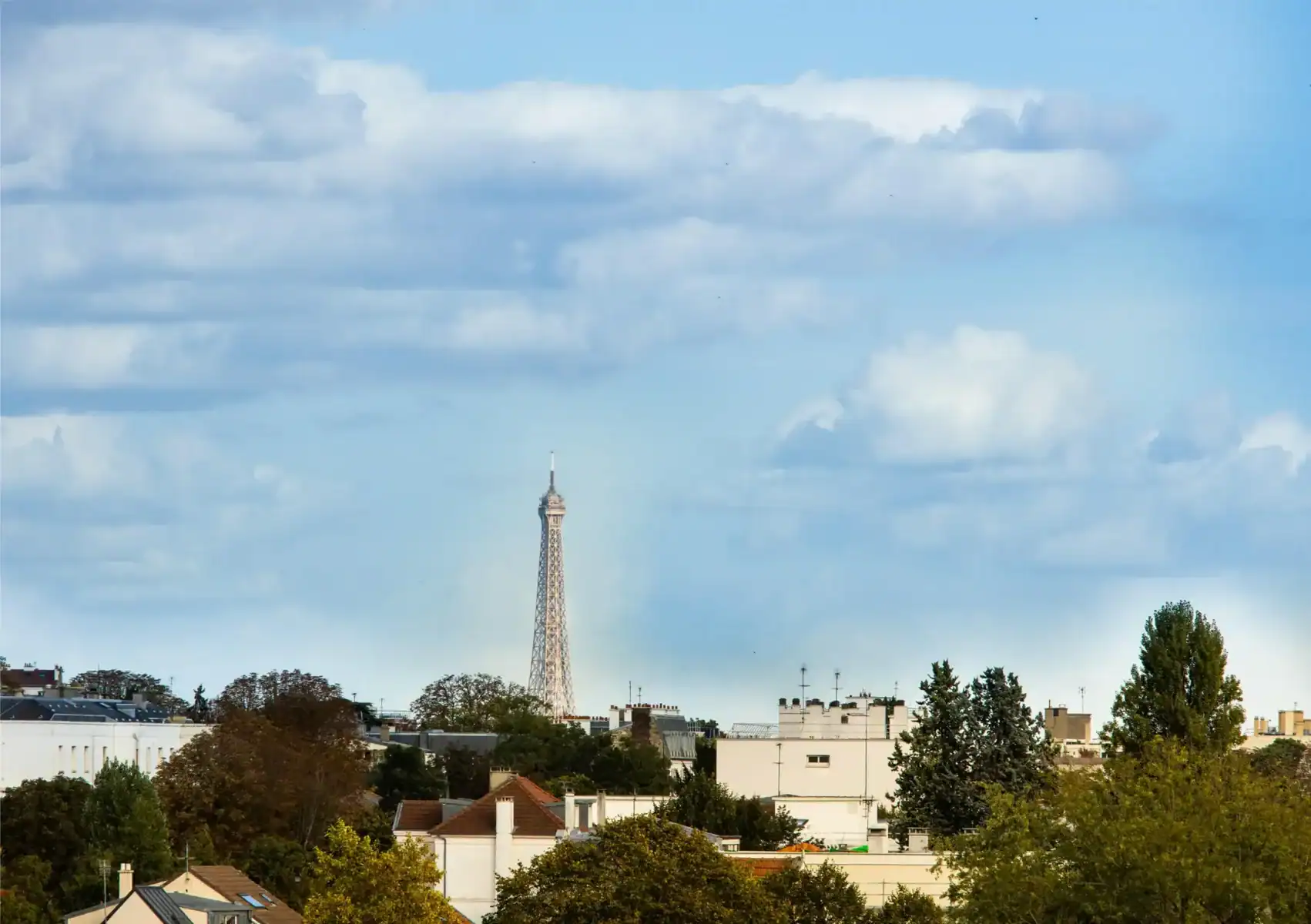Eiffel Tower view over Paris residential area, showcasing iconic Parisian cityscape and skyline.