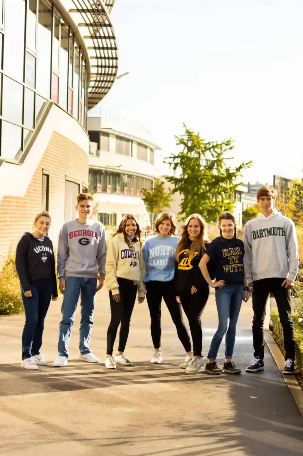 Students outside a modern school building, representing international education and campus life.