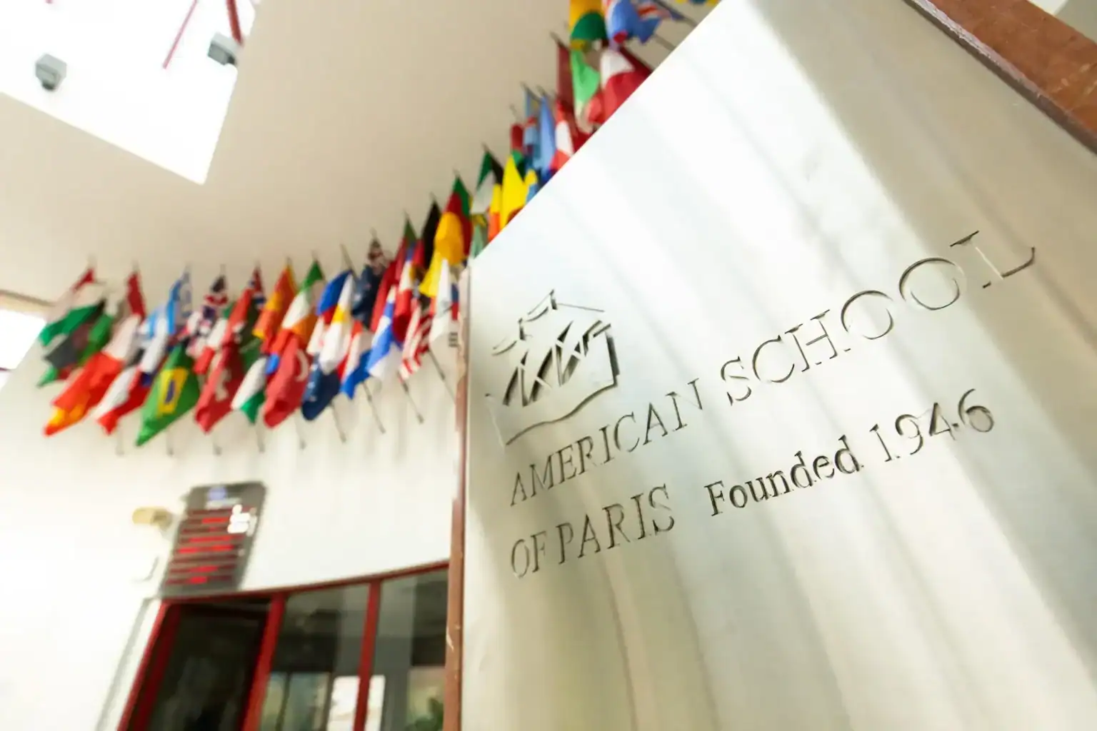 International flags display at American School of Paris, established in 1946, exemplifying global educational excellence.