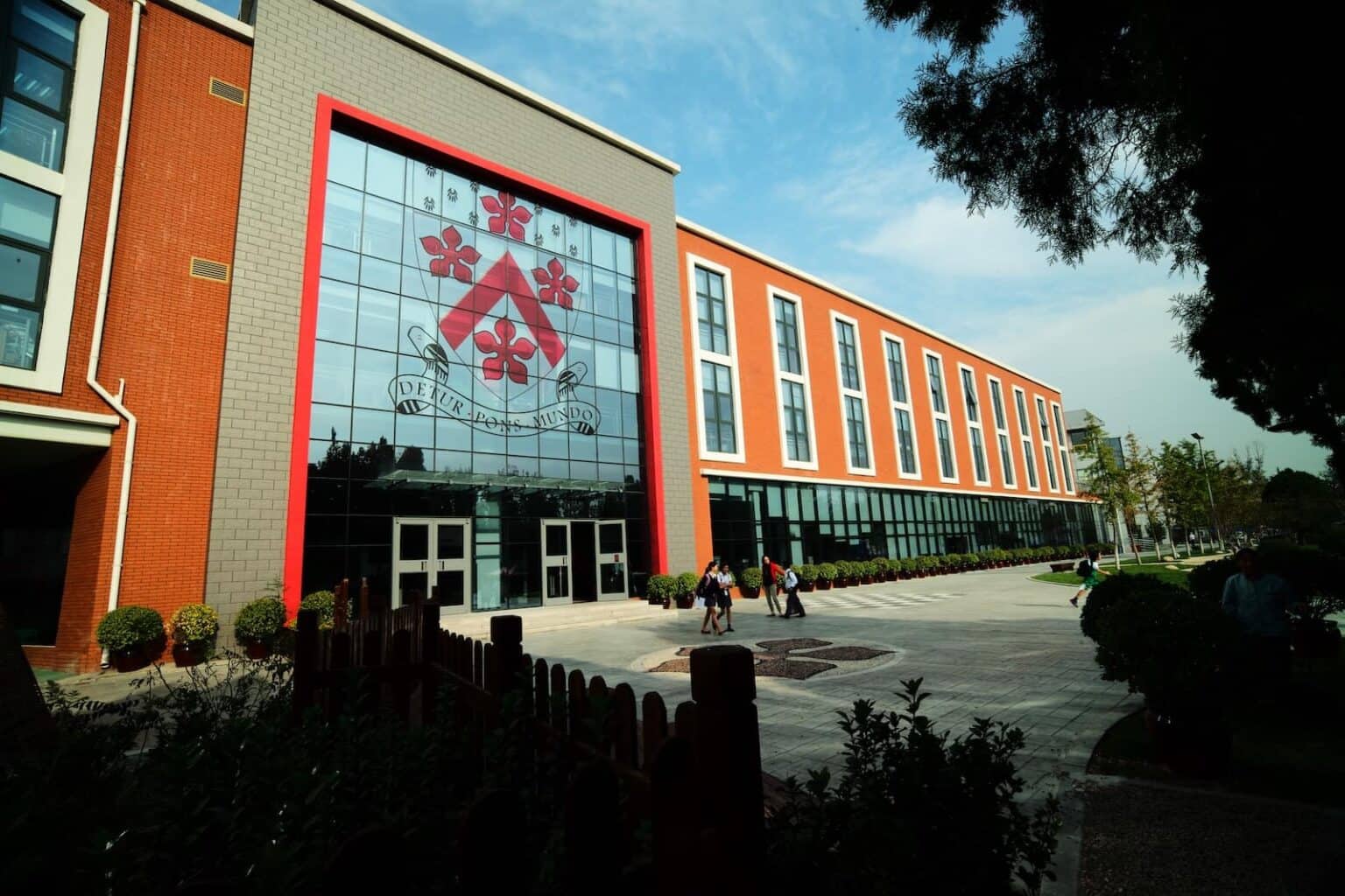 Exterior view of Dulwich College Beijing campus with modern architecture and large glass windows.