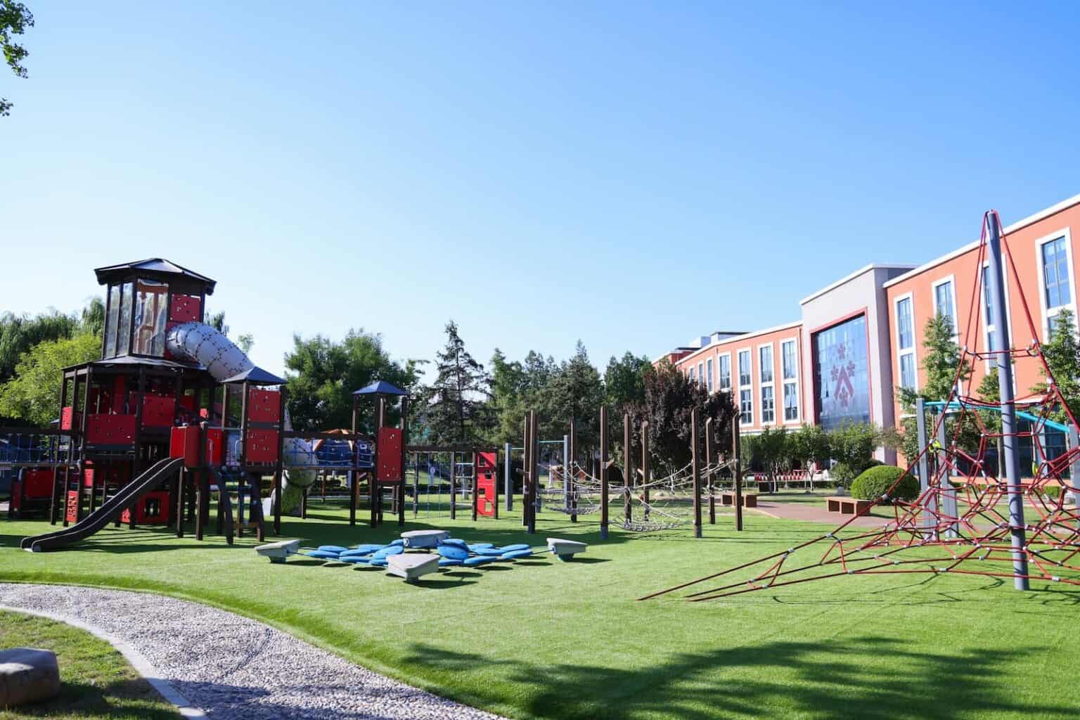 Playground at Dulwich College Beijing with modern play structures and green spaces.