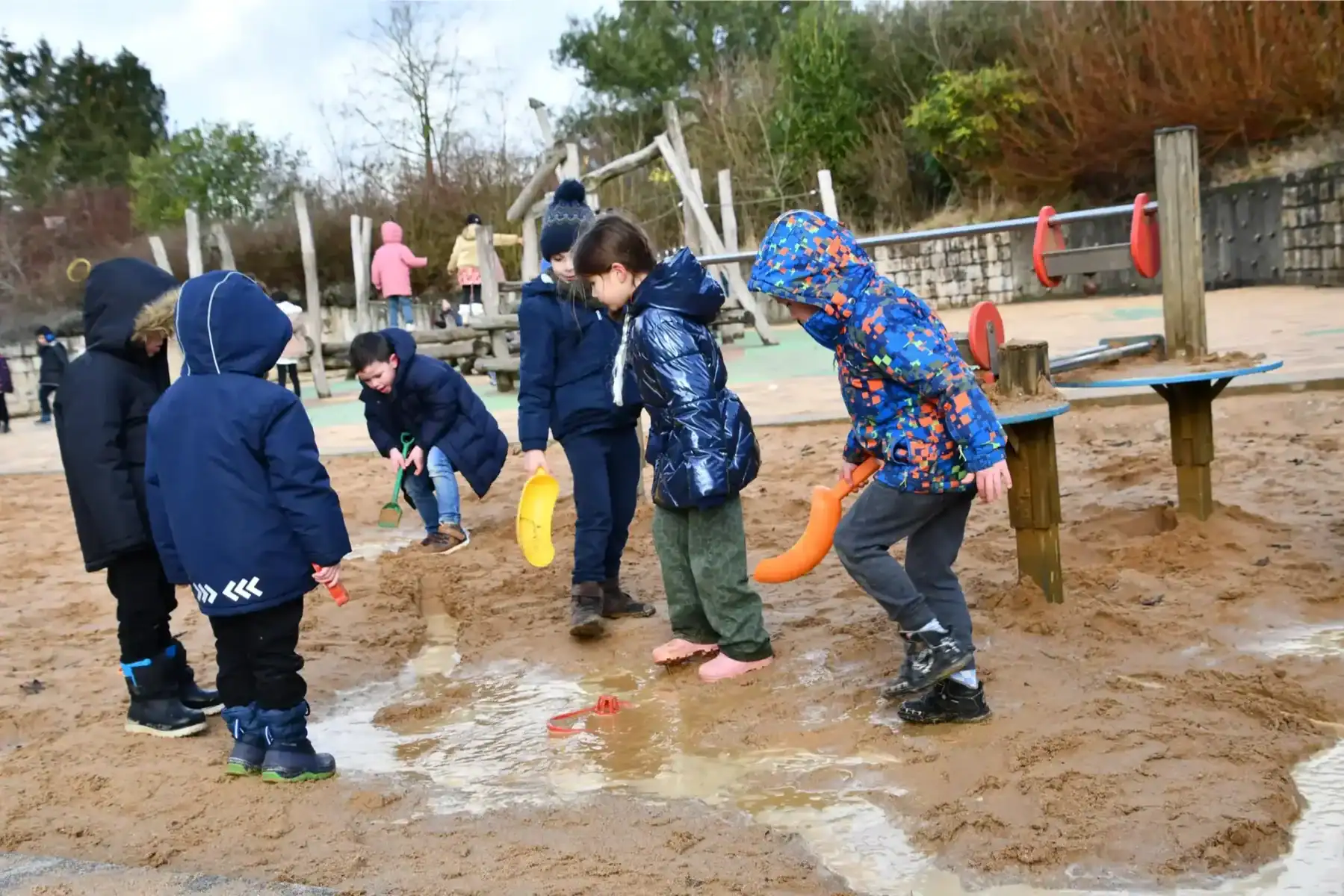 Children playing and exploring outdoors at a school playground.