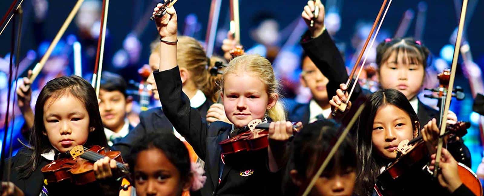 Children playing violins in a school orchestra at Dulwich College Bangkok.