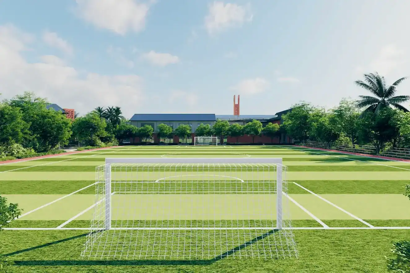 Sports field at Dulwich College Bangkok with goalposts and lush greenery.