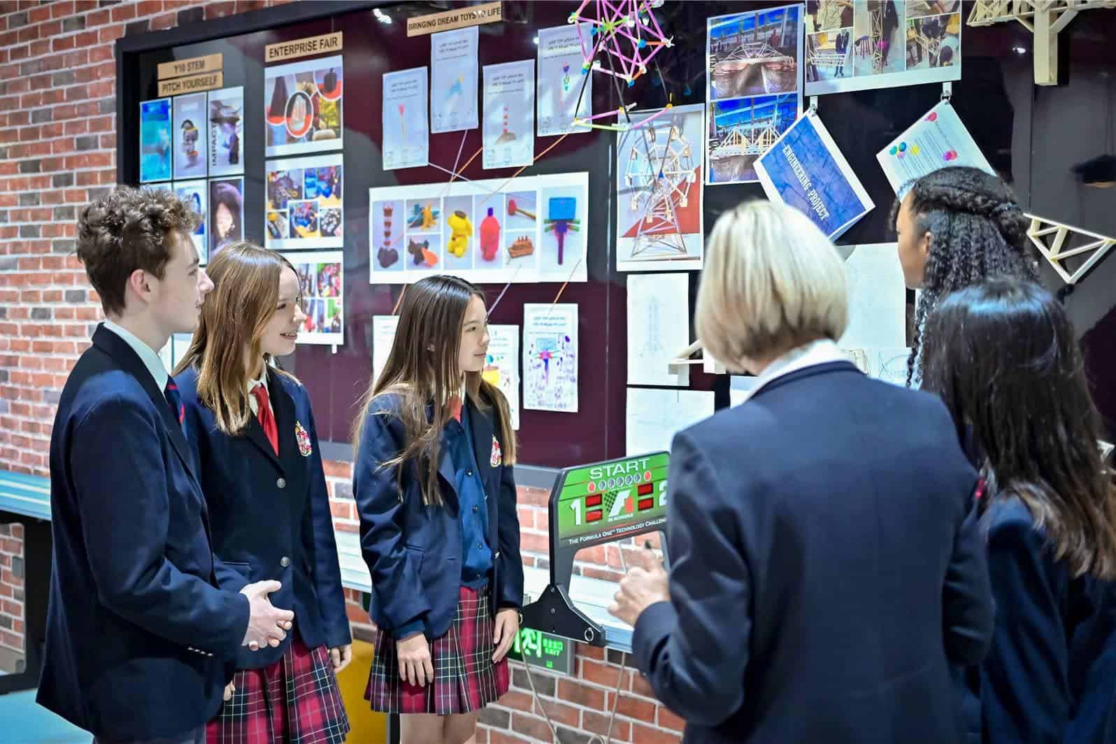Educational students discussing projects at school display.