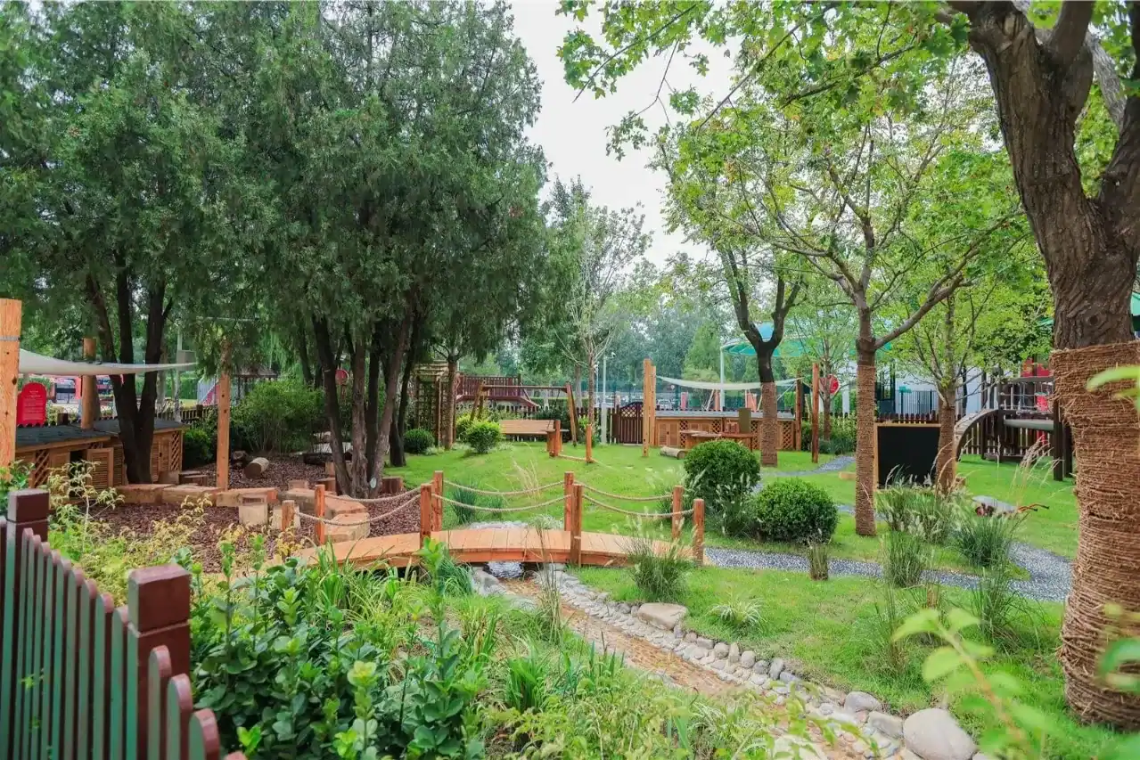 Beautiful outdoor garden at Dulwich College Beijing campus with trees and pathways.