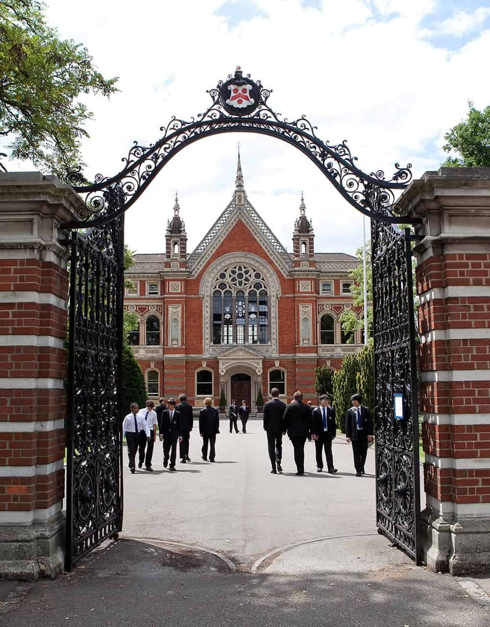 Historic college entrance with students outside.