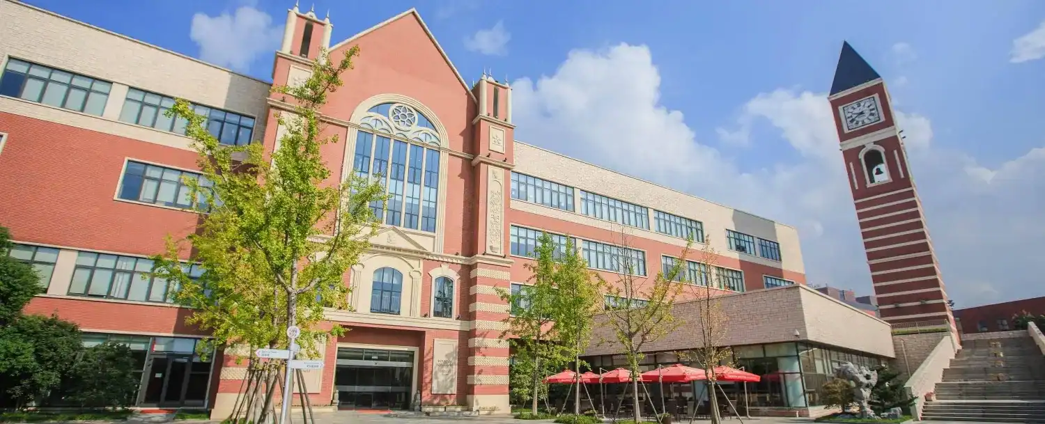 Modern view of Dulwich College Suzhou campus with historic architecture and clock tower.