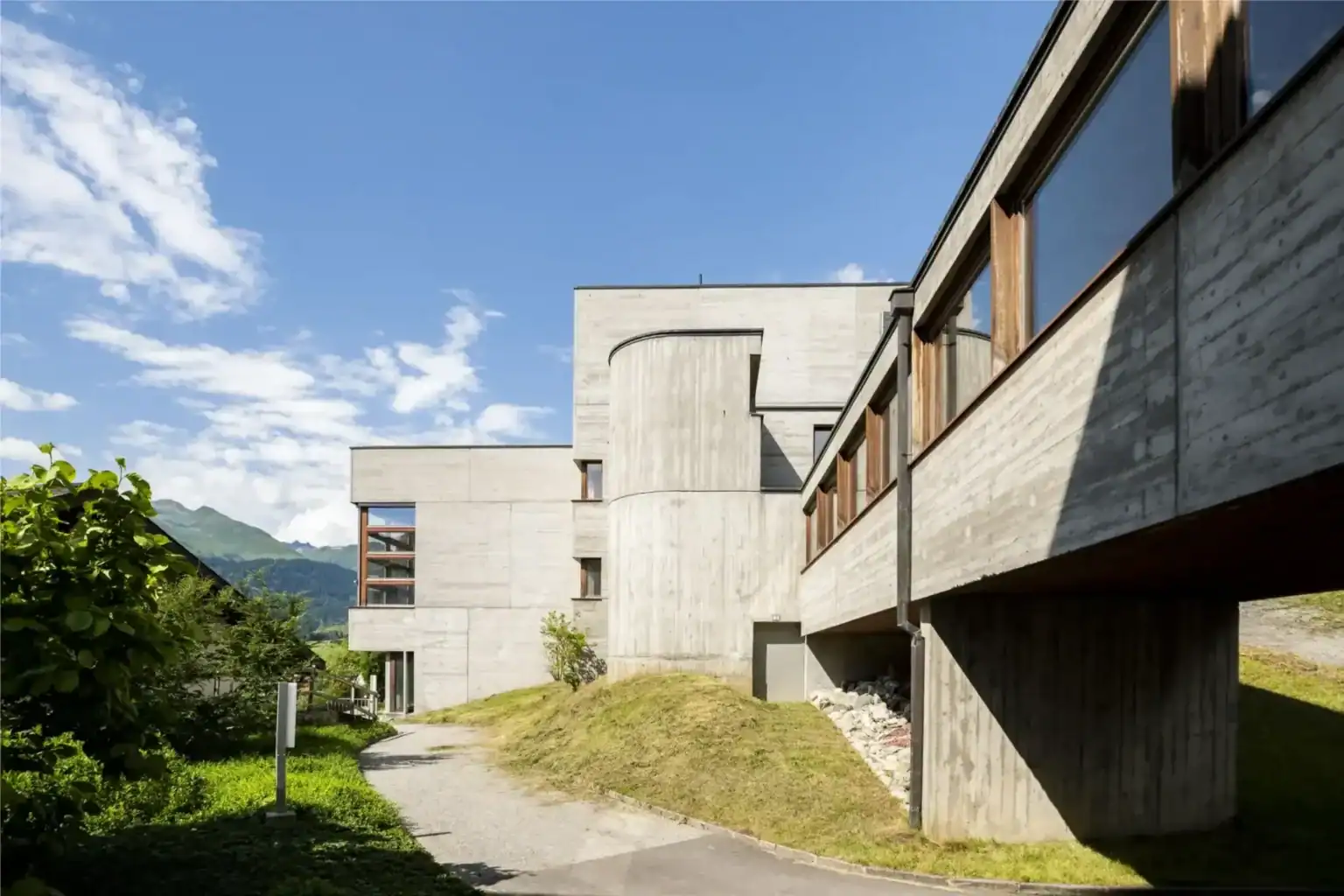 Contemporary gymnasium building at Kloster Disentis with scenic mountain views.
