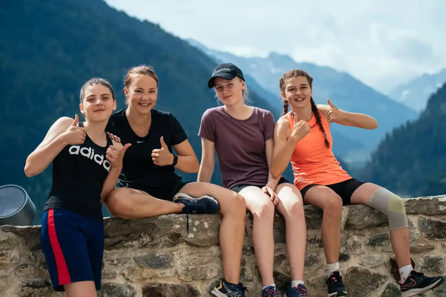Outdoor group of students at Kloster Disentis with scenic mountain background.