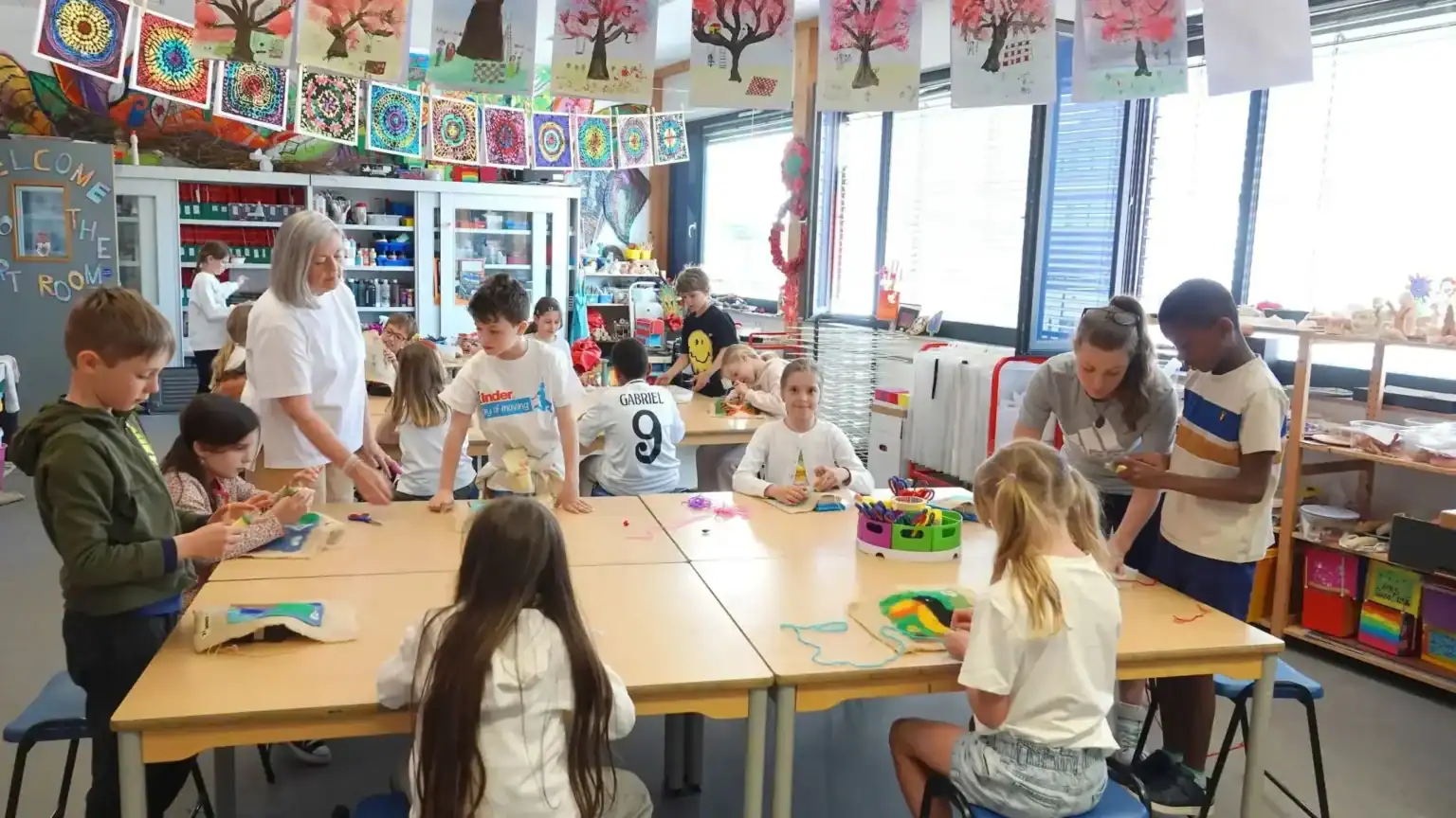 Students engaging in arts and crafts in a vibrant, well-equipped classroom environment.