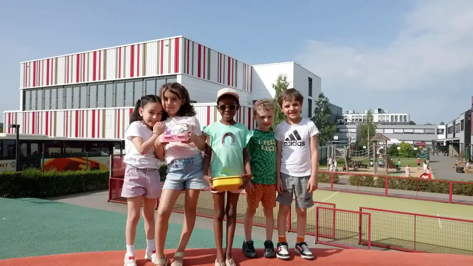 Children playing outside at St George's International School, Luxembourg, with modern campus buildin.