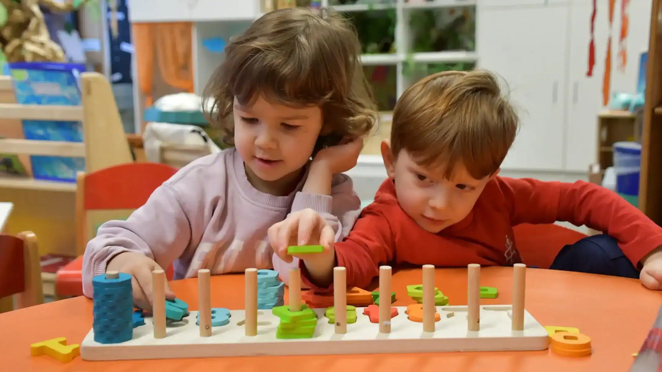 Children engaging with educational toys in a classroom setting.
