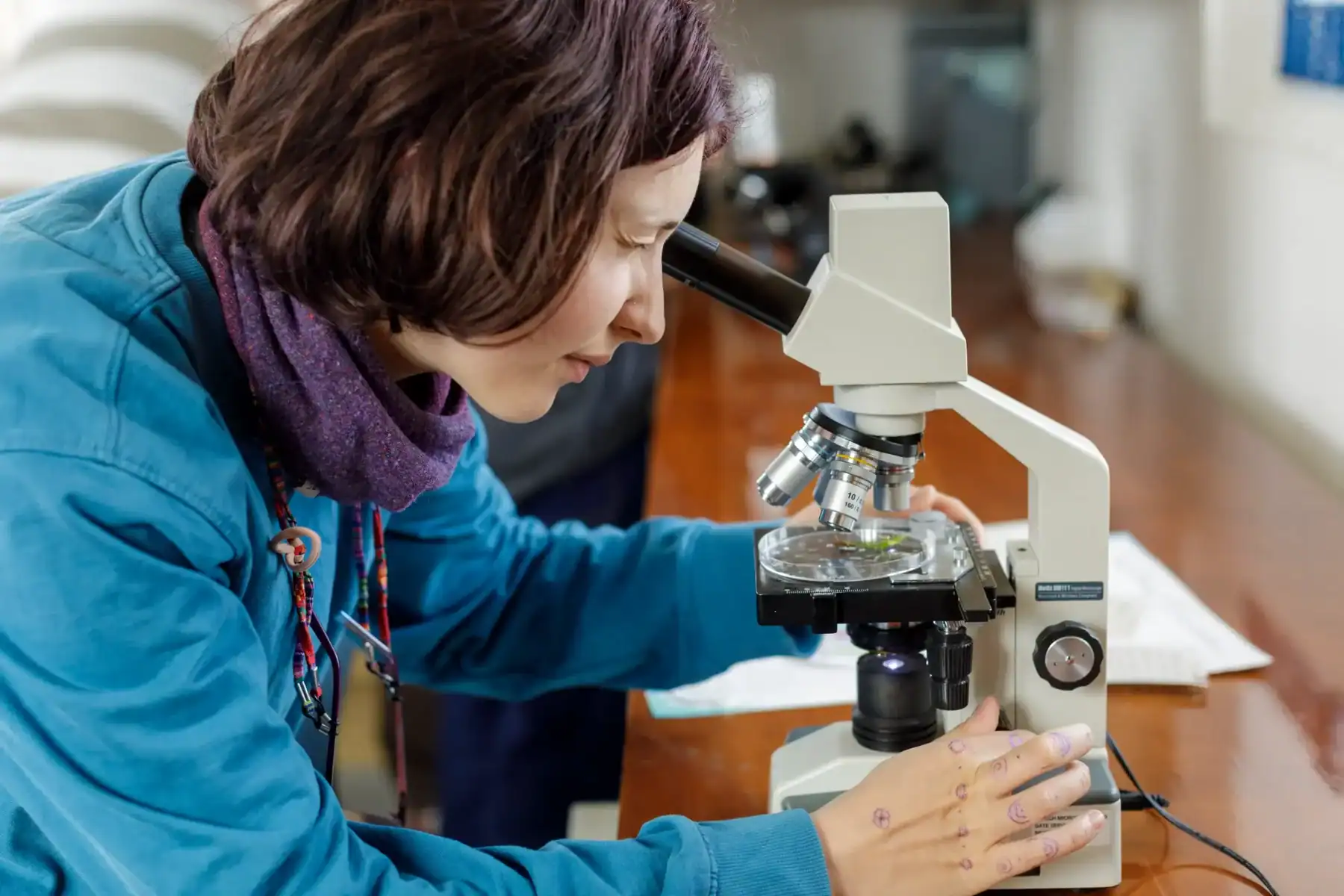 Science student using a microscope for research at Brockwood Park School.