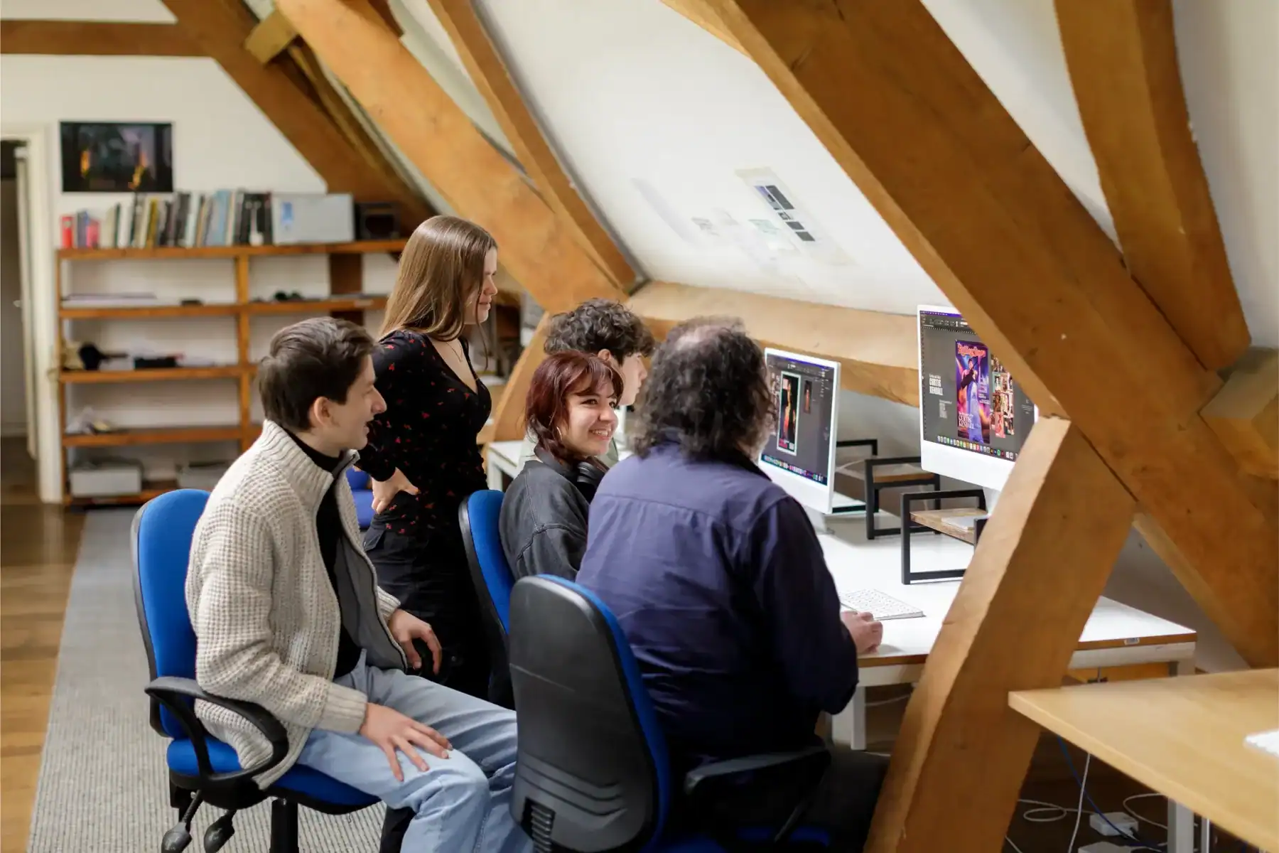 Students collaborating on digital art projects in a modern classroom setting.