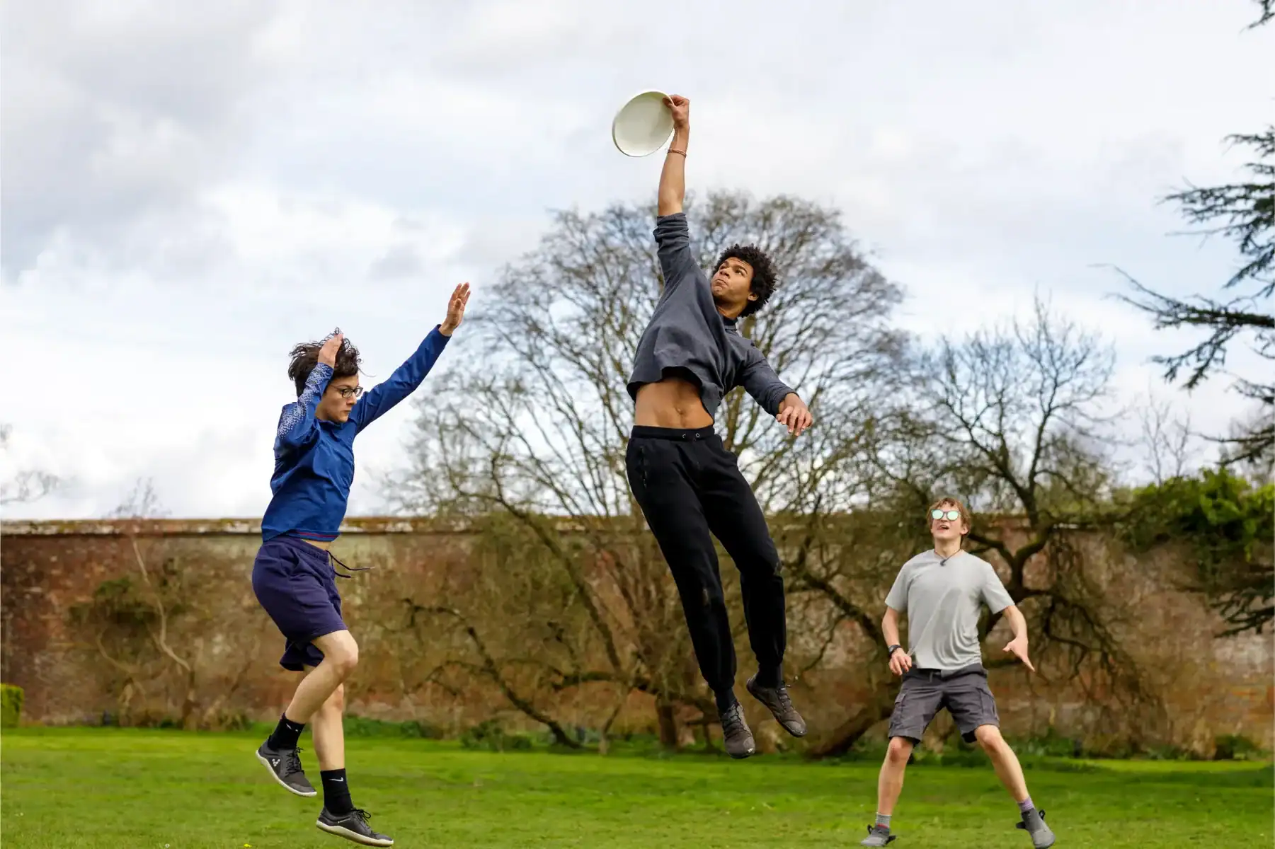 Students playing frisbee on school grounds at Brockwood Park School.