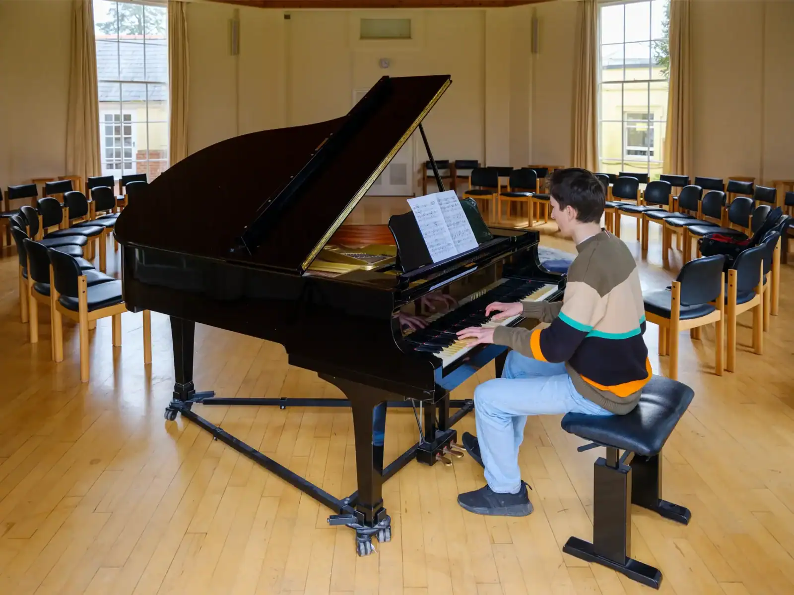 Elegant grand piano in a spacious music room at Brockwood Park School.