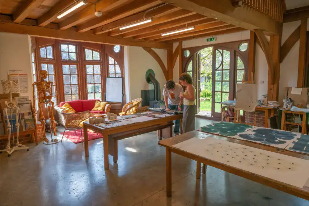 Creative classroom at Brockwood Park School with large windows and wooden beams.