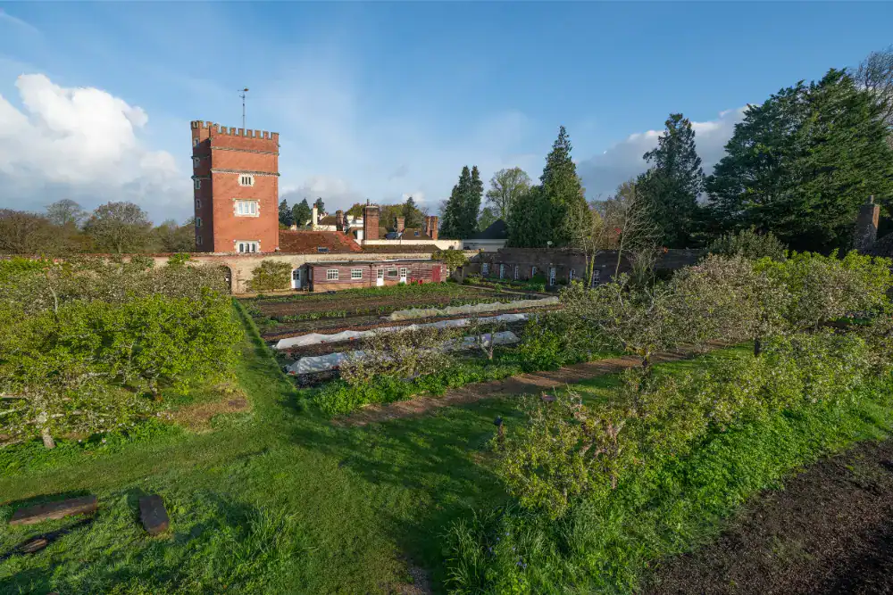 Brockwood Park School historic tower and lush gardens in a scenic setting.
