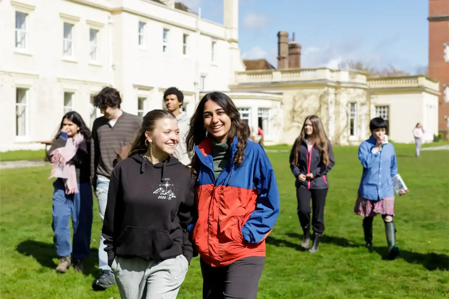 Students walking outside Brockwood Park School campus in sunny weather.