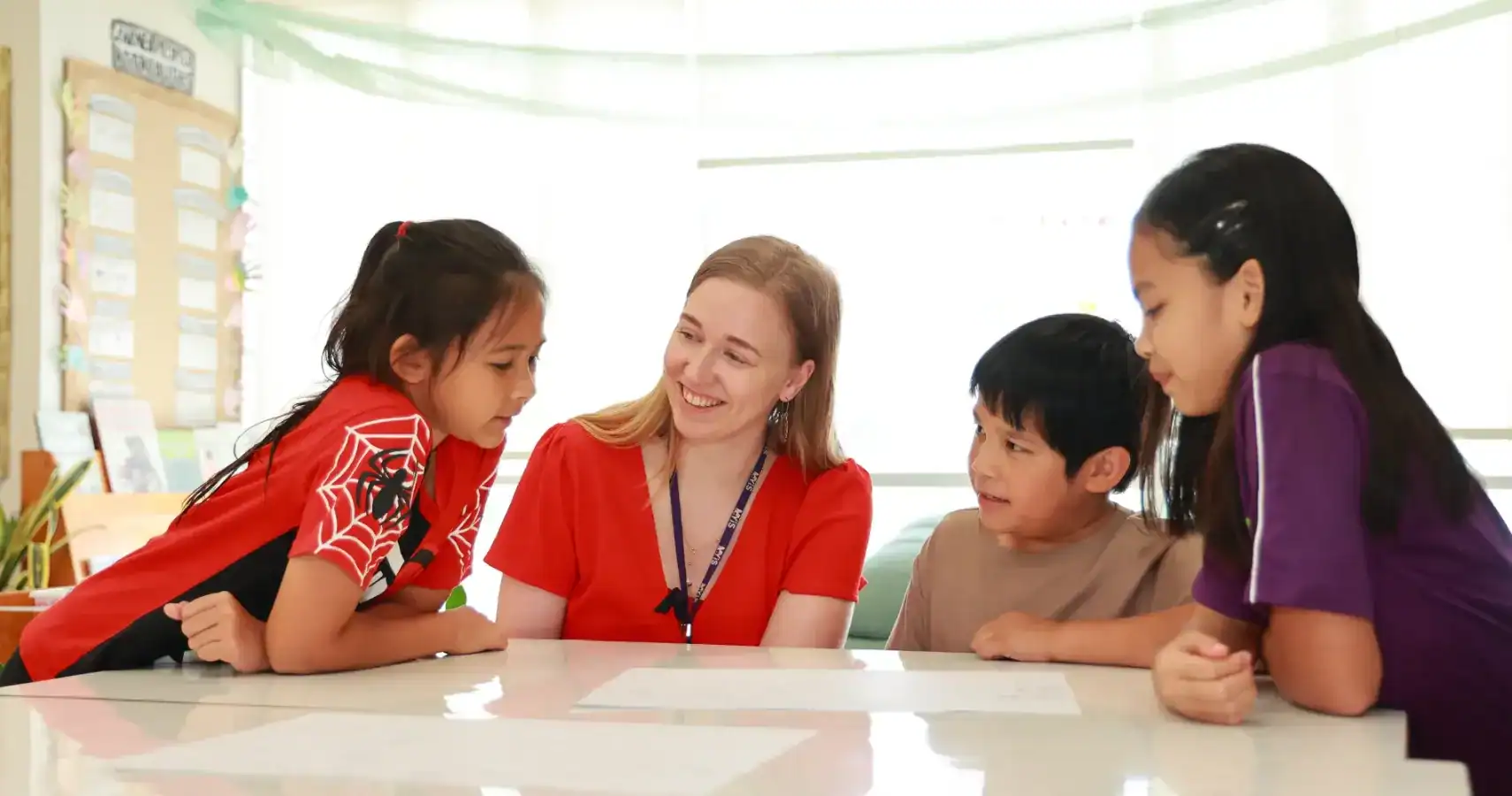 Children and teacher engaging in classroom learning activity.