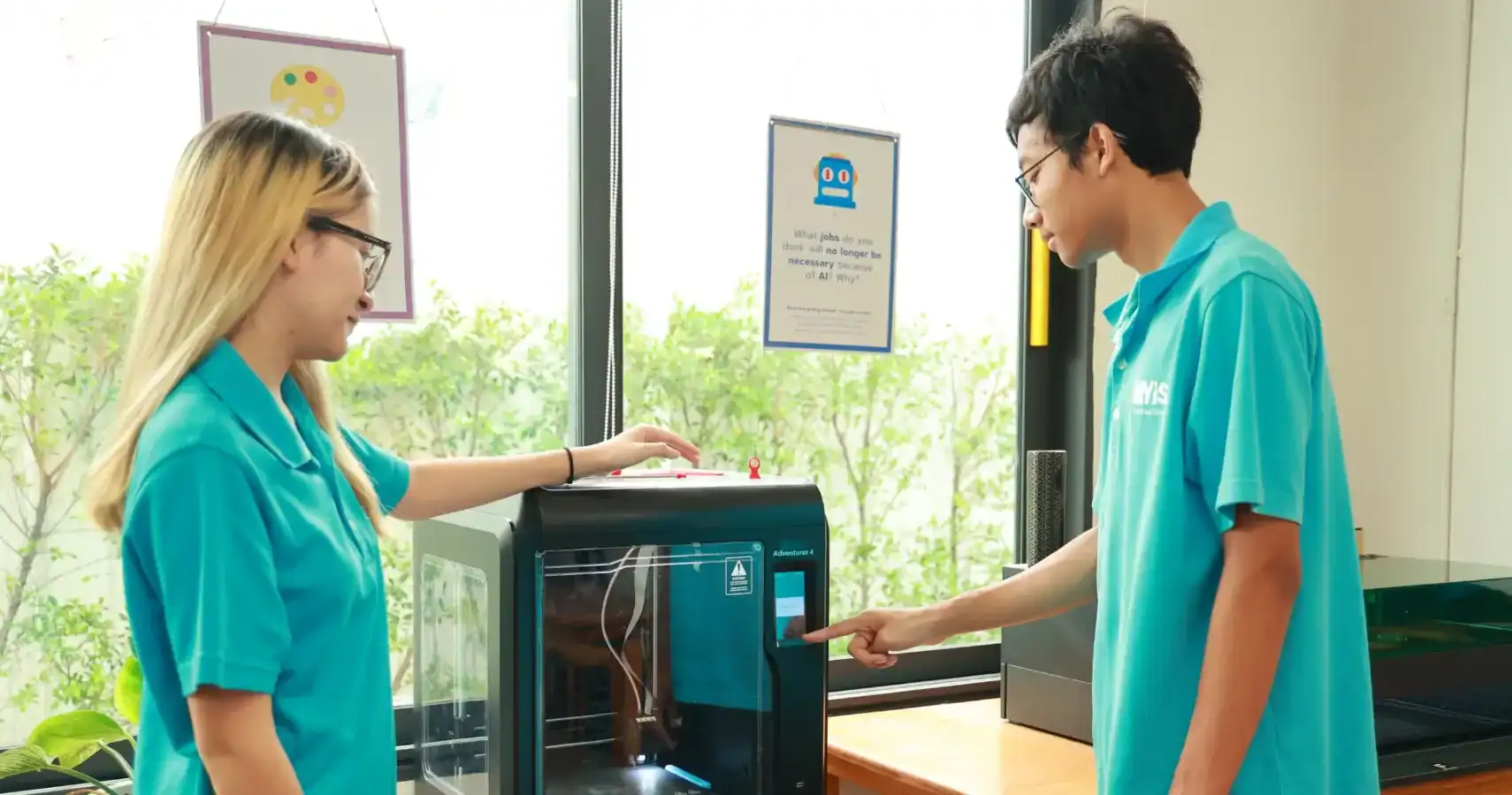 Students using 3D printer at MYIS International School classroom.