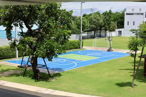 Outdoor basketball court with vibrant blue surface at MYIS International School.