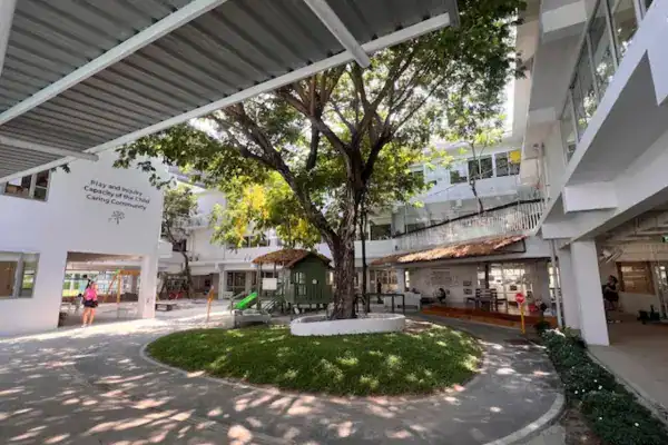 Outdoor view of MYIS International School with trees and shaded areas for students.
