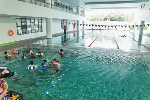 Swimming pool at MYIS International School with students learning to swim.