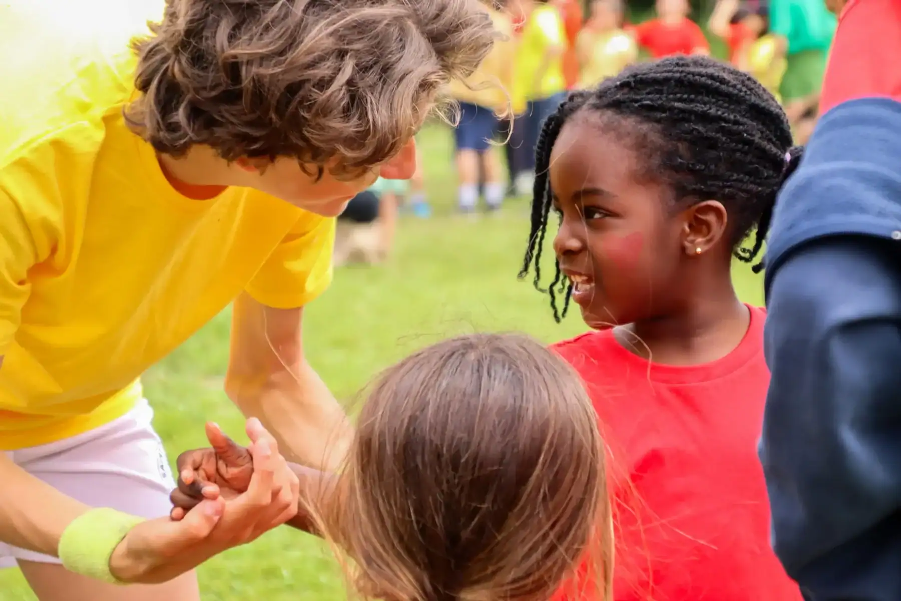 Children playing and smiling outdoors at a school event.