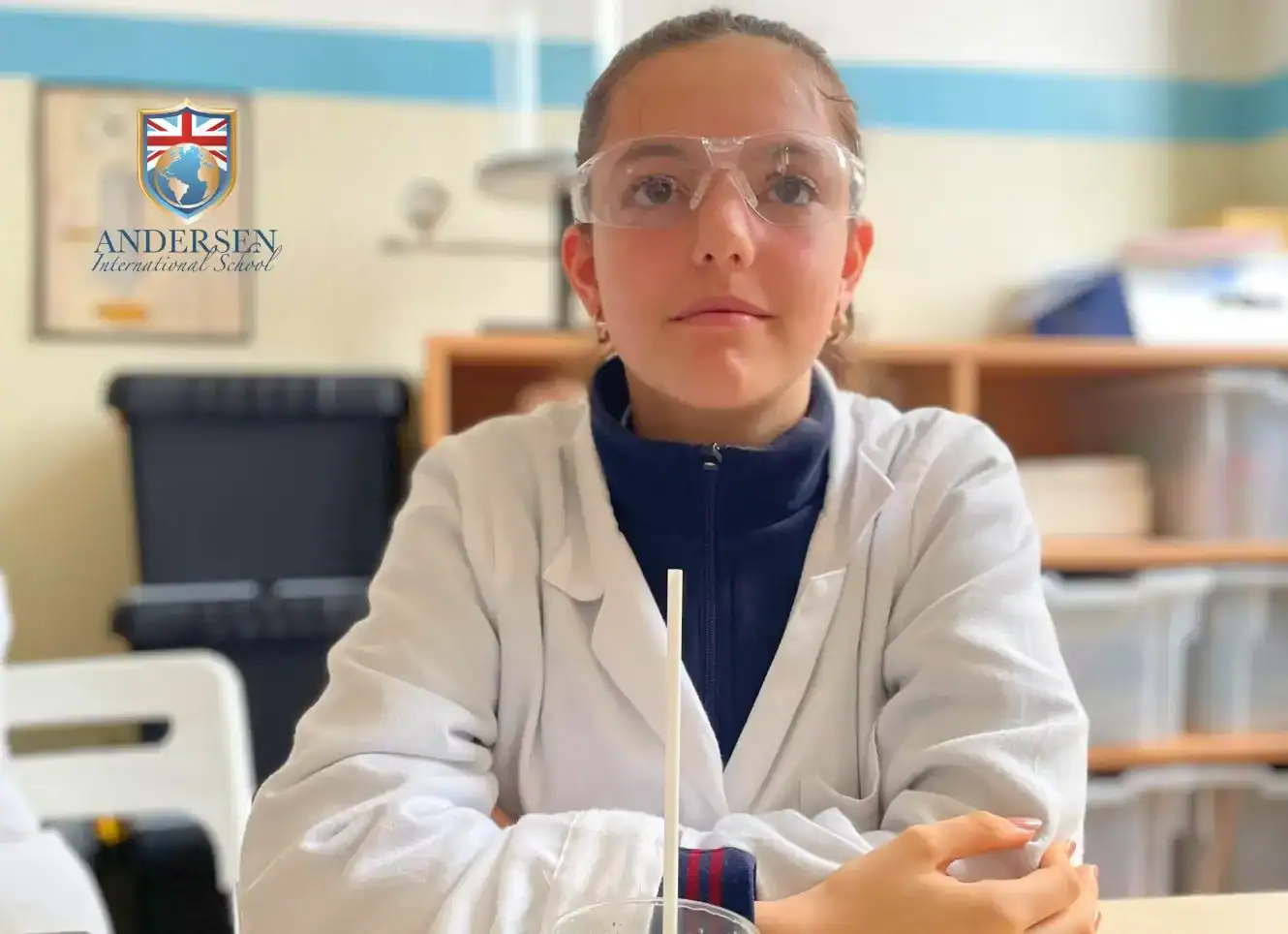 Student in science lab wearing safety goggles at Andersen International School.