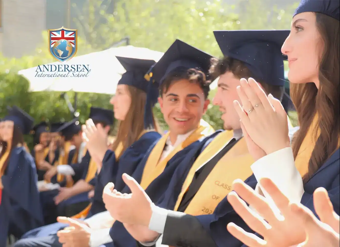 Graduates in caps and gowns celebrating at Andersen International School graduation ceremony.