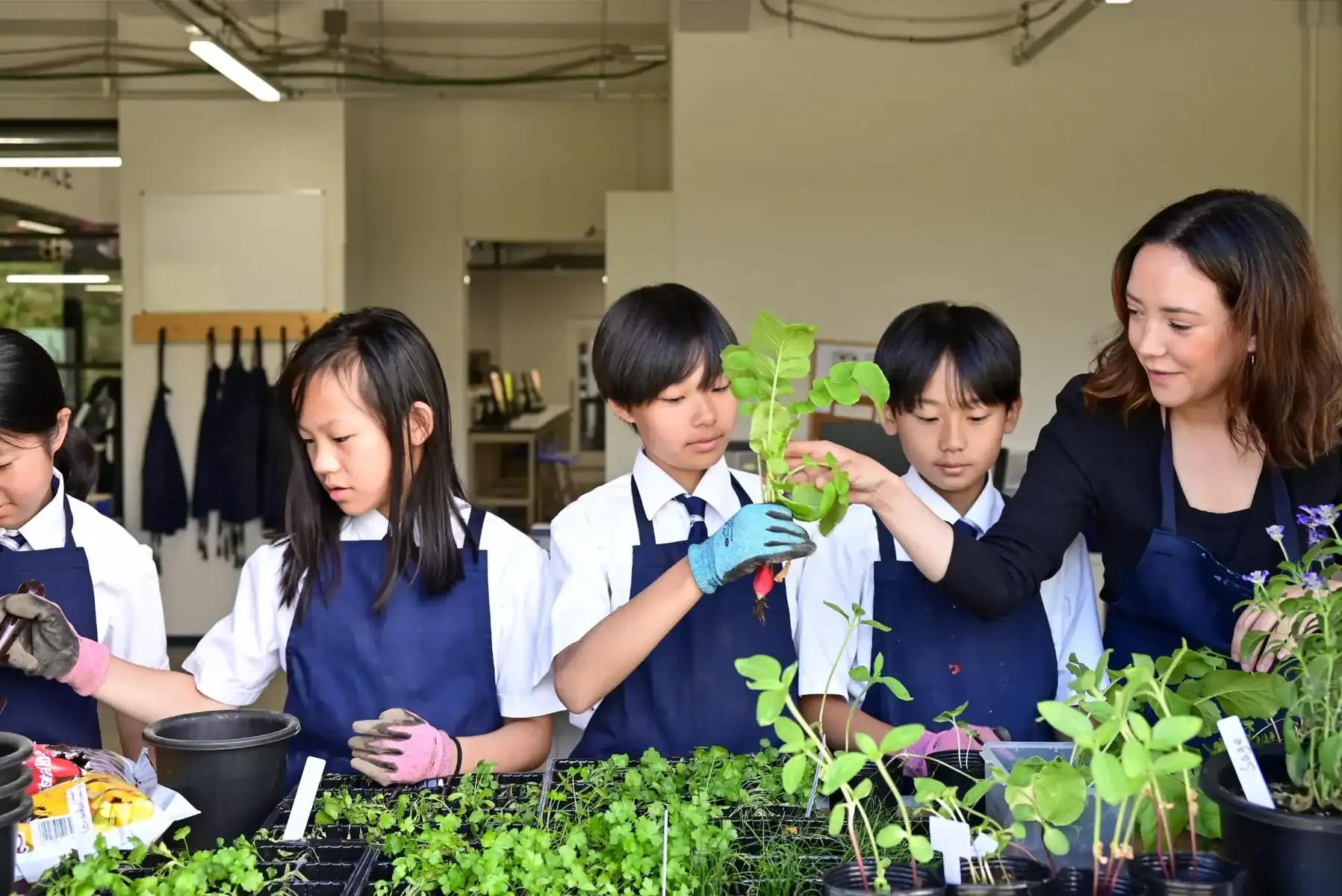 Students and teacher engaging in a gardening activity at Harrow International School Appi Japan.