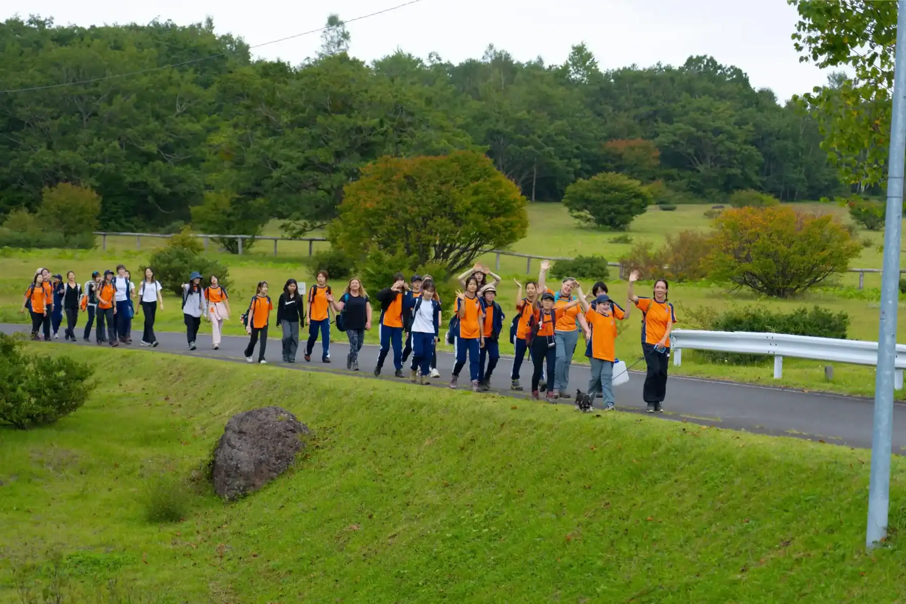 Students walking outdoors in a lush green landscape at Harrow International School Appi Japan.