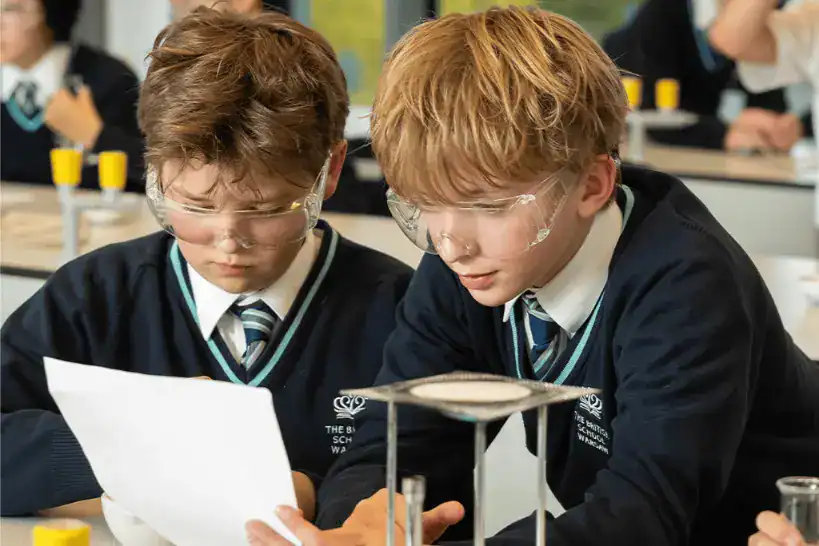 Two young students conducting a science experiment in a classroom at The British School Warsaw.