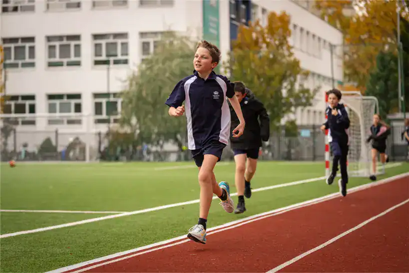 Students running on a school track at The British School Warsaw.