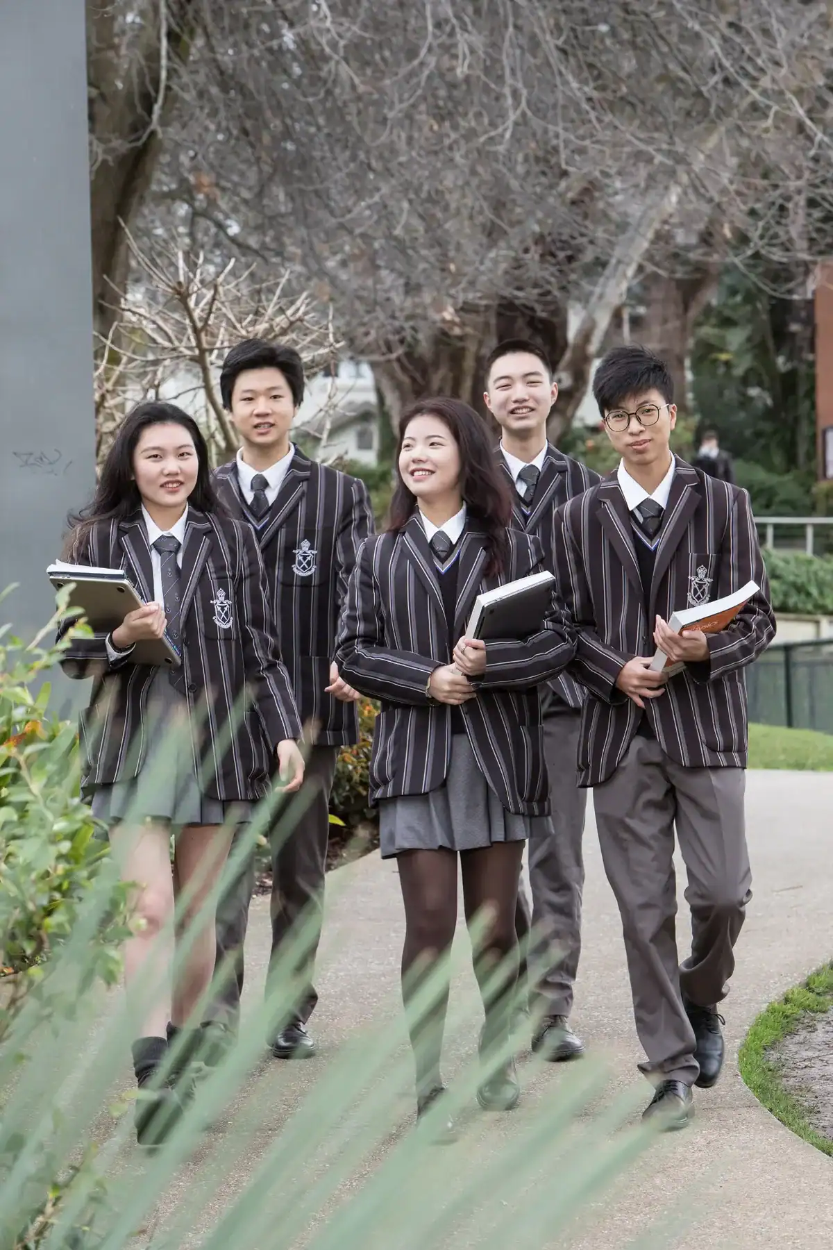 Students in striped uniforms walking outdoors at Ivanhoe Grammar School.