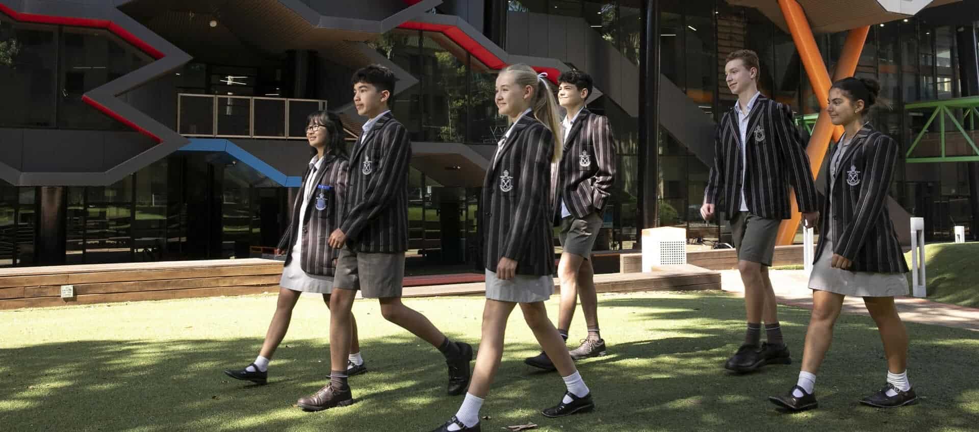 Students walking outside Ivanhoe Grammar School in uniform.