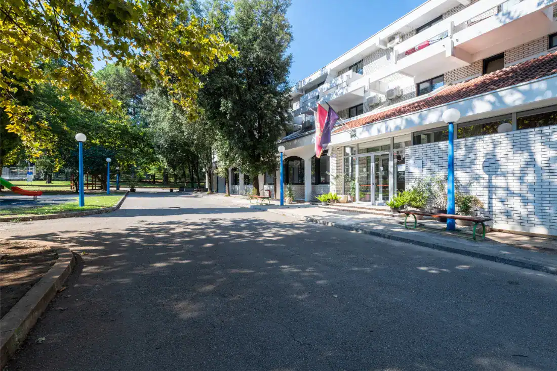 School entrance with trees and modern building in Montenegro.